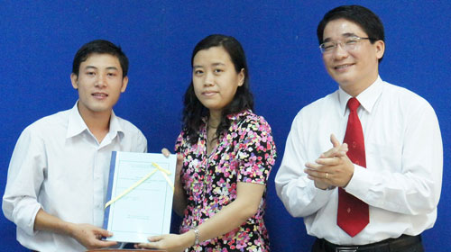 Bạn Trần Văn Thành (bìa trái) trao công trình nghiên cứu Tội phạm trong lĩnh vực chứng khoán cho đại diện đơn vị tiếp nhận - Ảnh: PHI LONG